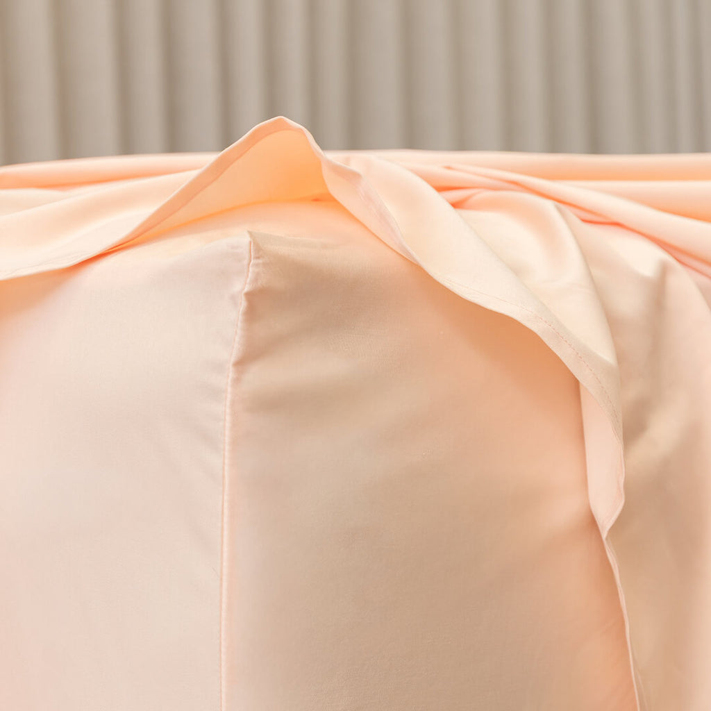 Close-up of peach-colored fabric with a neutral background.