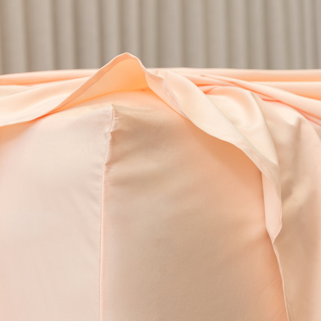 Close-up of peach-colored fabric with a neutral background.