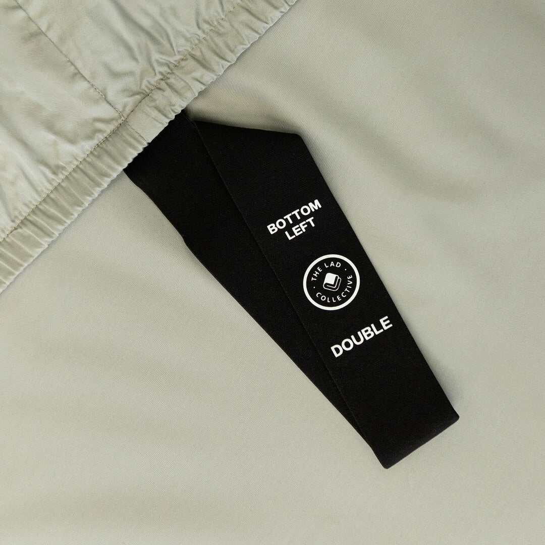 Light grey fitted sheet with labelled corner strap.