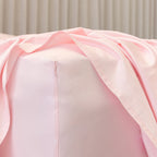 Close-up of a pink fitted sheet corner fabric on bed.
