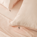 Close-up of blush pink pillowcases with concealed zipper closures, showcasing the secure fastening detail and clean, streamlined finish.