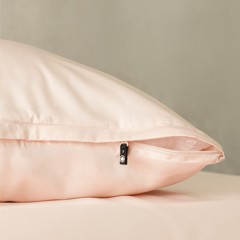 Close-up of a blush pink pillowcase featuring a concealed zipper closure, highlighting the secure fastening detail and soft, elegant fabric finish.