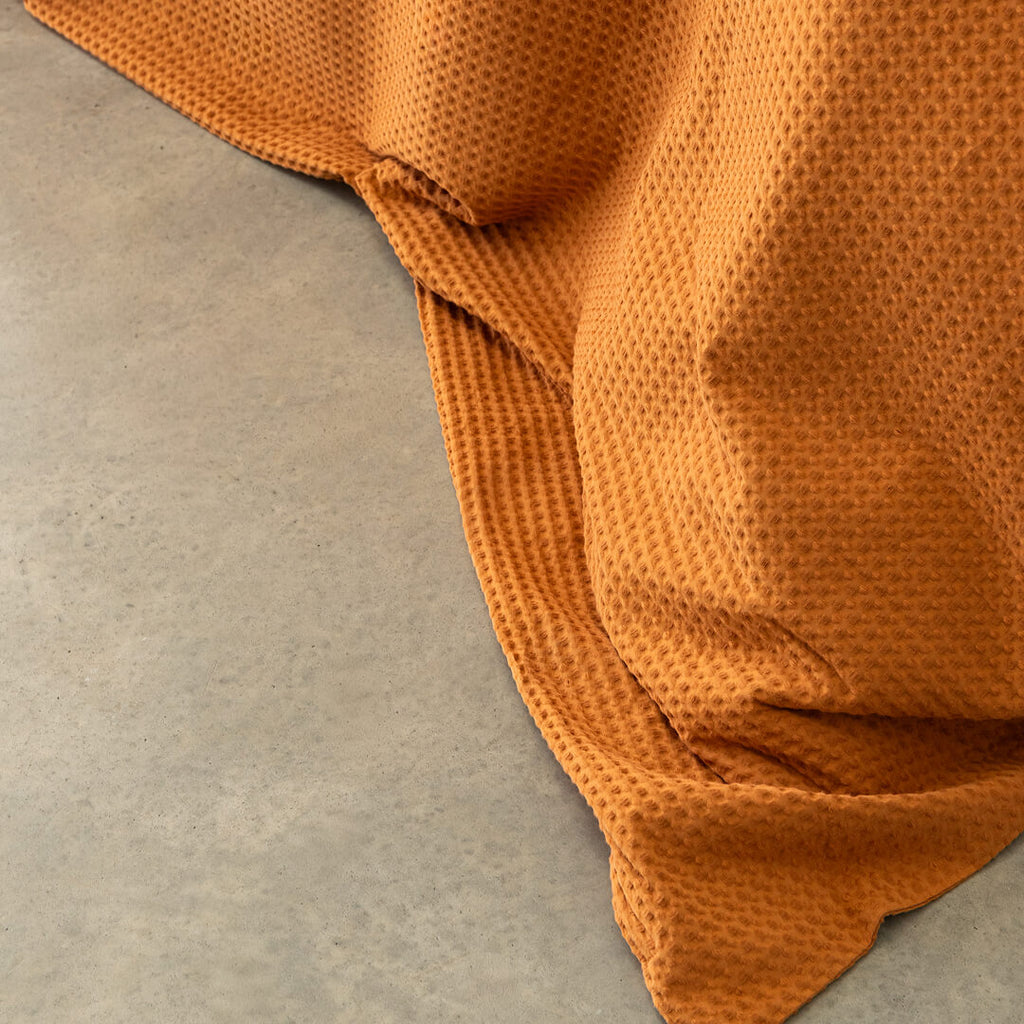 Orange textured fabric draped over a neutral surface
