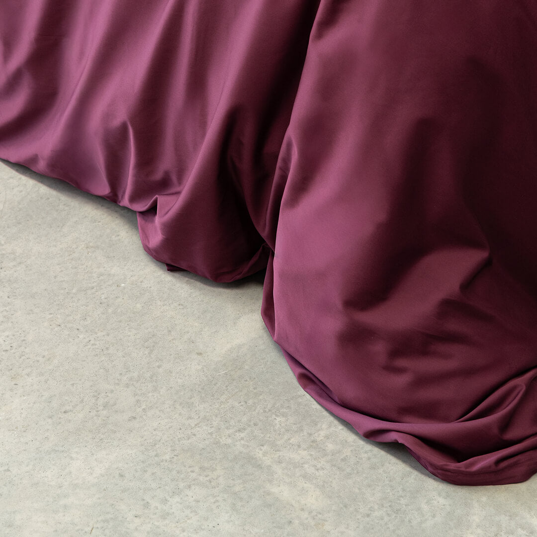 Close-up of burgundy bedding on a light gray surface