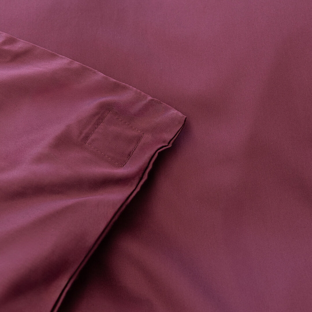 Close-up of a maroon fabric with a magnetic corner detail.