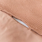 Close-up of a clay coloured, waffle textured fabric with a zipper.