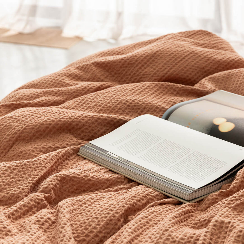 Book on a textured pink blanket with a blurred background.