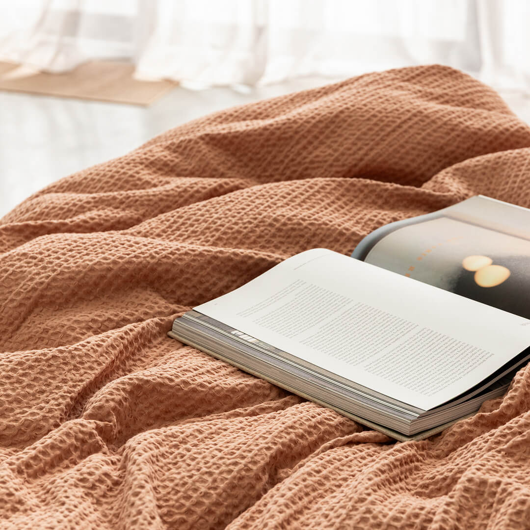 Book on a textured pink blanket with a blurred background.