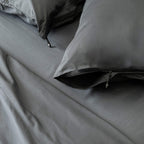 Grey bedding set with pillows on a bed