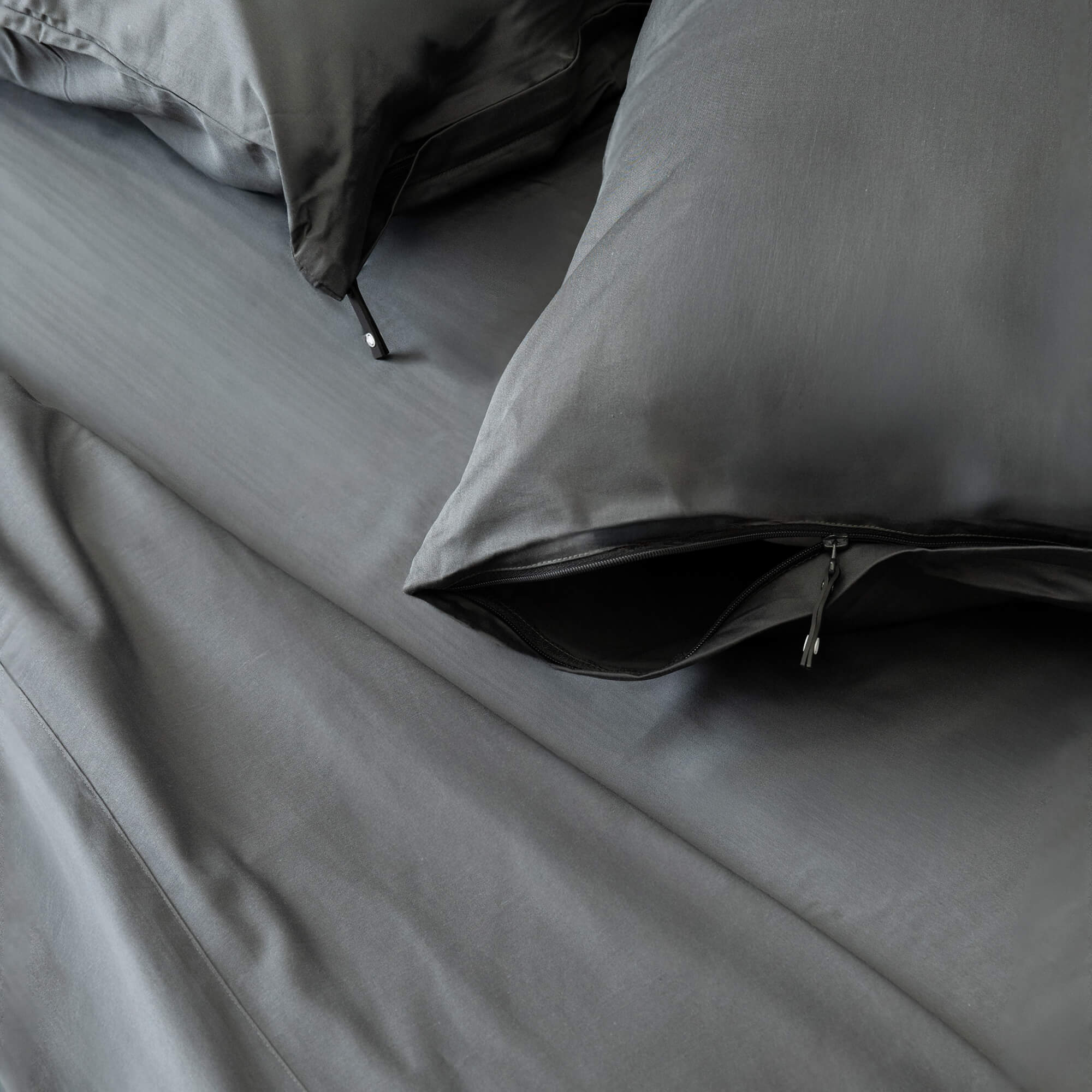 Grey bedding set with pillows on a bed