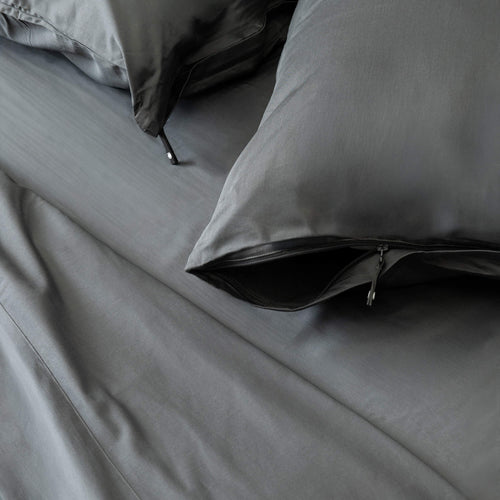 Grey bedding set with pillows on a bed