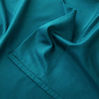 Close-up of teal fabric with a pocket detail