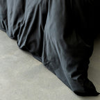 BLACK comforter on a bed with a light background