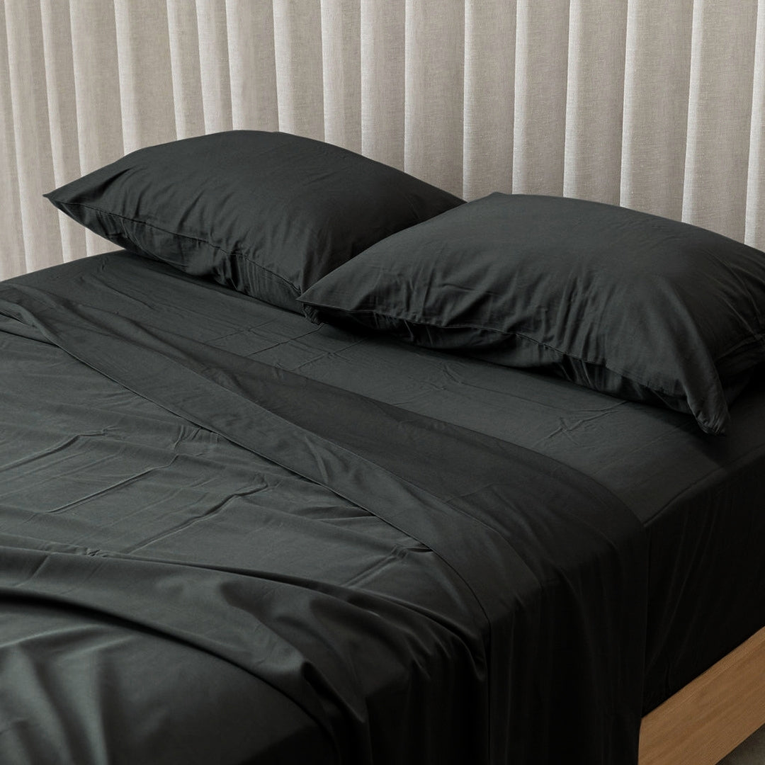 Black bedding set on bed. 