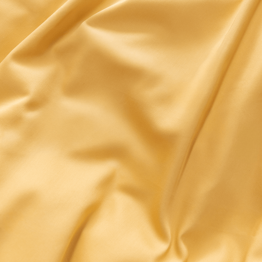 Extreme close-up showing the soft drape and silky sheen of golden yellow fabric