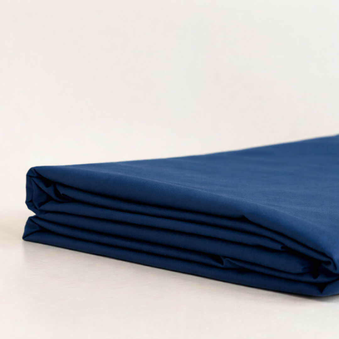 Folded blue fabric on a white background.