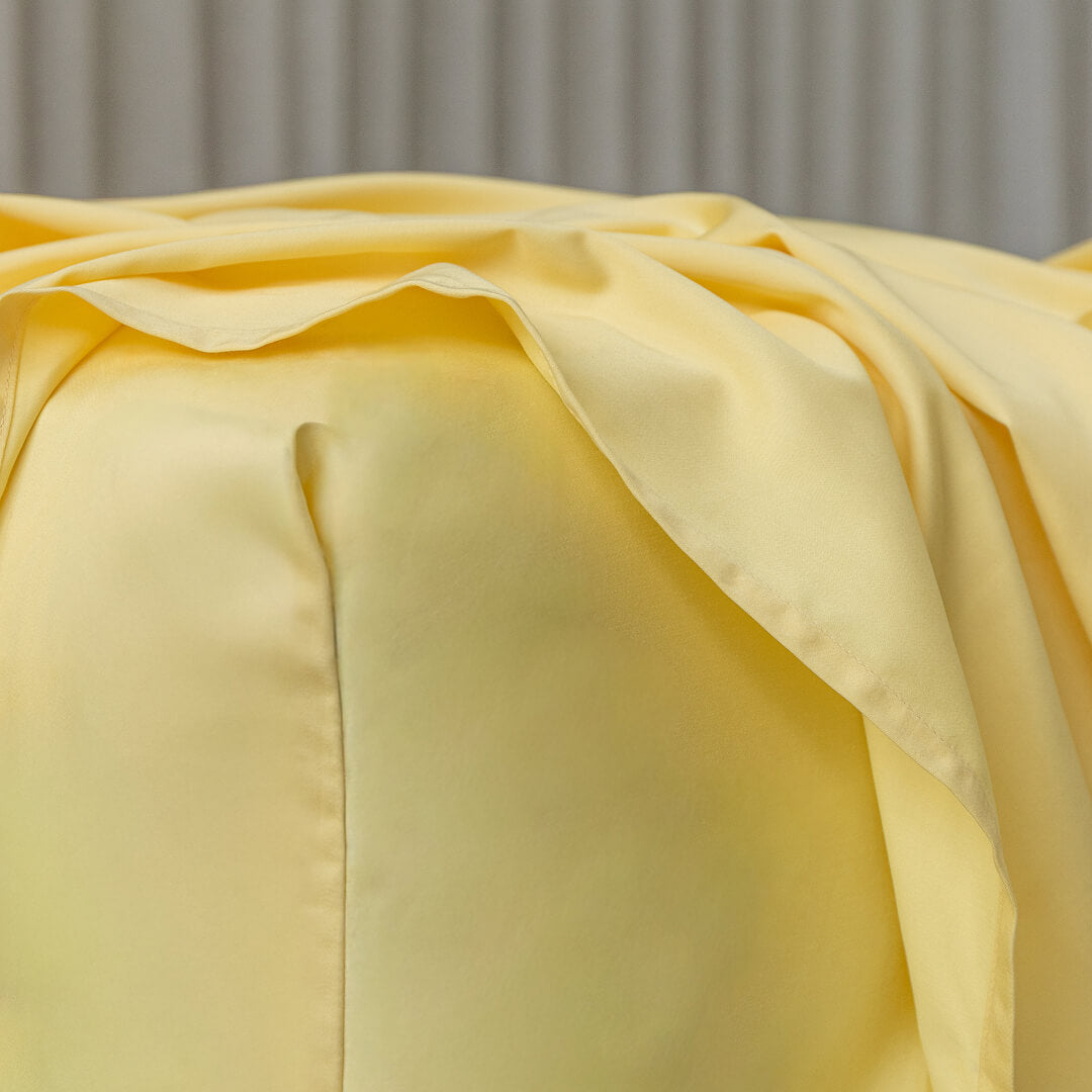 Close-up of a yellow fabric with a soft texture against a neutral background.