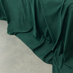 Dark green fabric draped over a neutral surface.