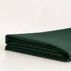 Folded forest green fabric on a light beige background.