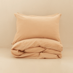 Neatly folded peach quilt cover with one matching pillowcase resting on top