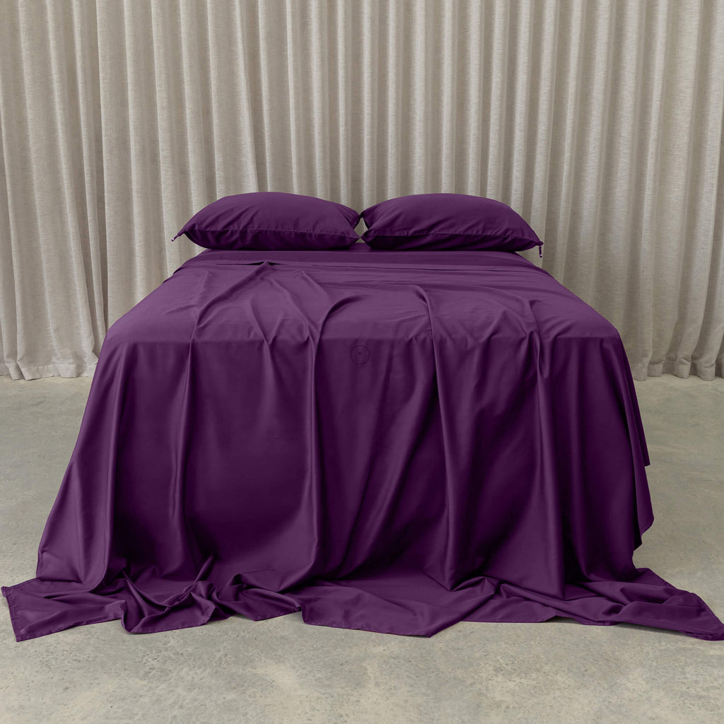Purple Bed sheets with curtain background.