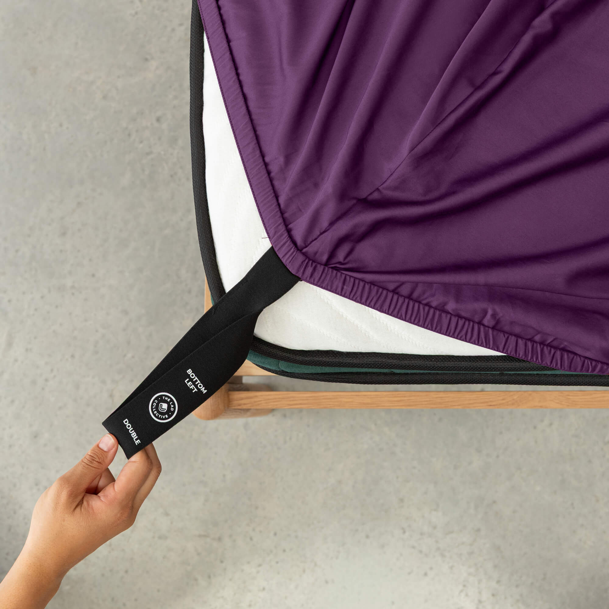 Close up of corner strap pull in purple bedding on concrete floor