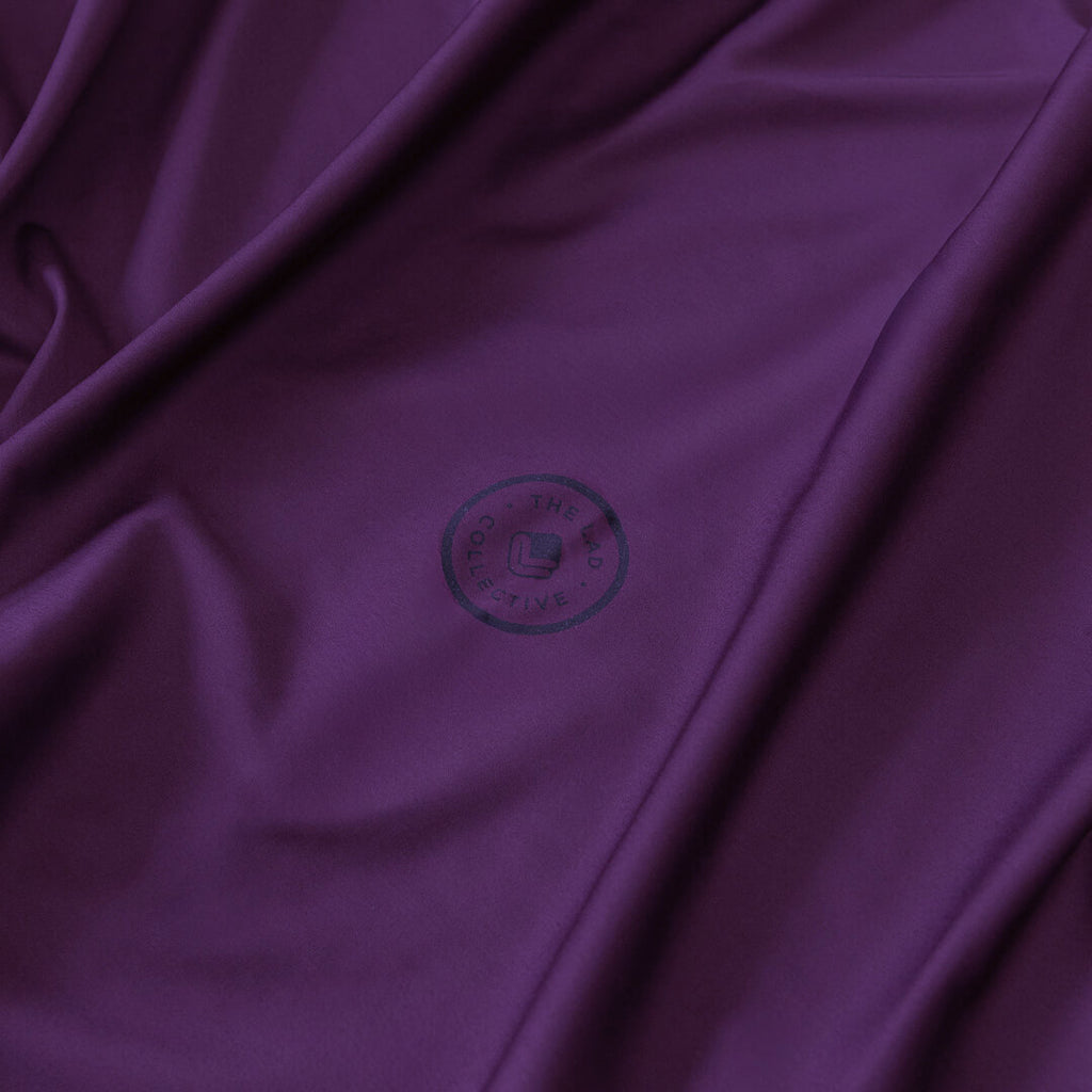 Close-up of purple fabric with a brand logo in the center.