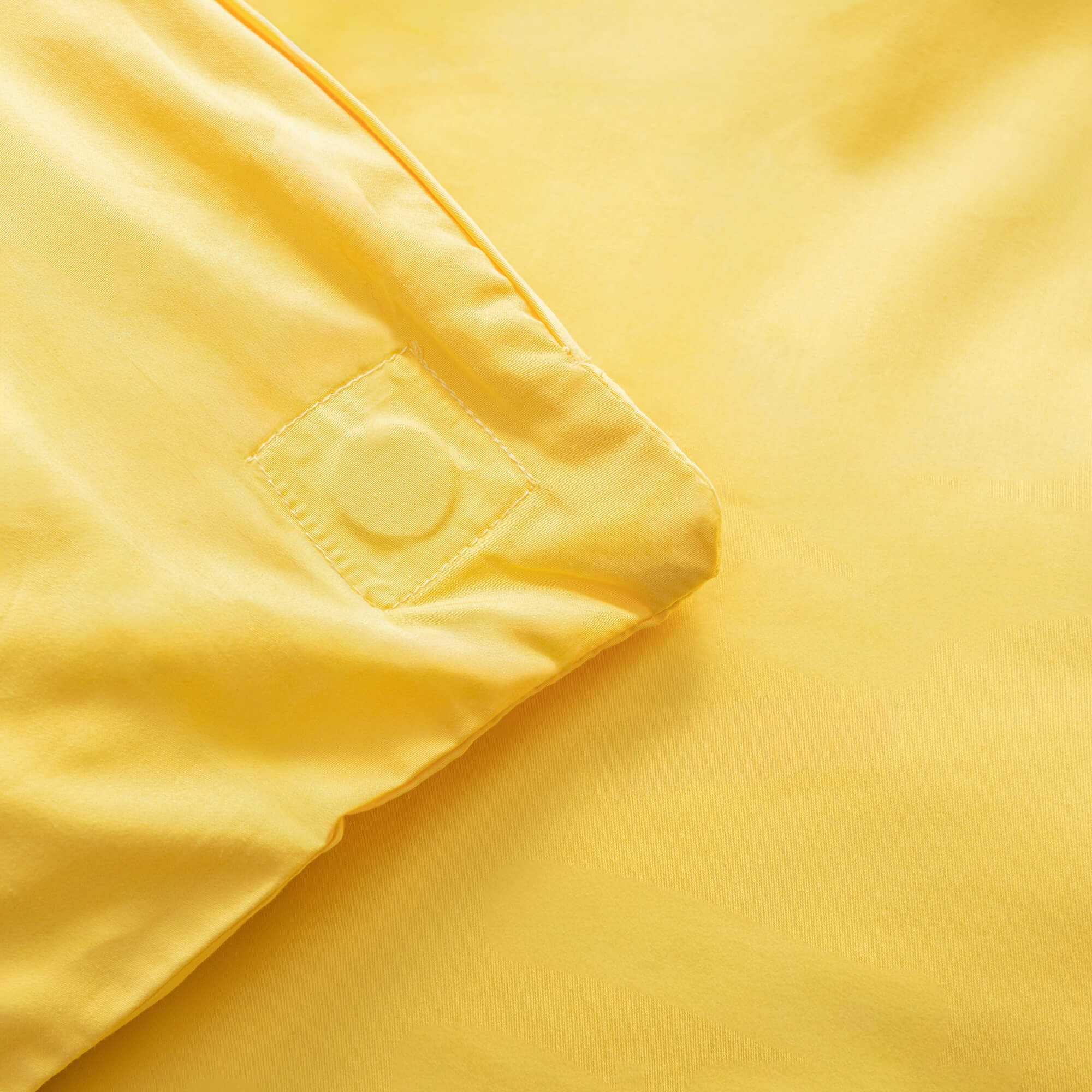 Close up of the magnetic corners in a bright yellow quilt cover. 