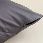 Grey pillow on a beige background, close up of zipper closure.