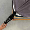 Charcoal grey fitted sheet with an orientation tag extended from the mattress corner, demonstrating the easy-to-identify labeling system for quick bed setup.