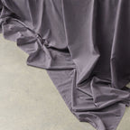 Gray ruffled fabric on a light green surface.