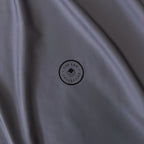 Close-up of a grey fabric with a logo in the center.