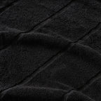 Close-up of black textured towel fabric with diagonal lines.
