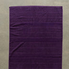 Purple towel on a beige surface.