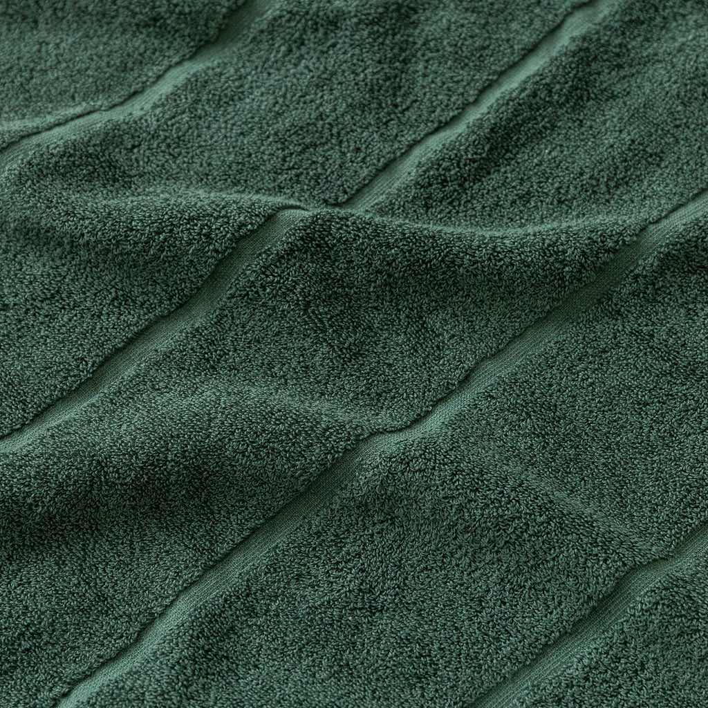 Close-up of textured green towel fabric with folds.
