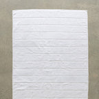 White bath towel laid flat on concrete background.