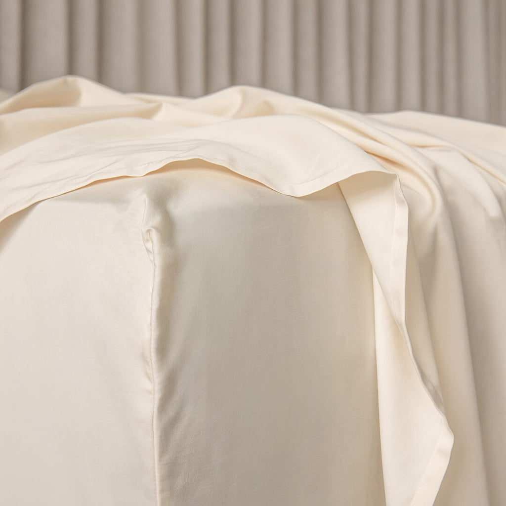 Close-up of cream fabric with a soft texture against a neutral background.