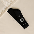 Black labelled corner loop strap that says 'Bottom Left' on cream fitted sheet.