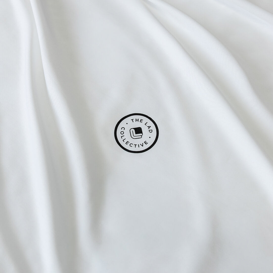 White fabric with a black circular logo and text on a white background.