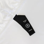 Close up of corner pull strap of fitted sheet in white bedding