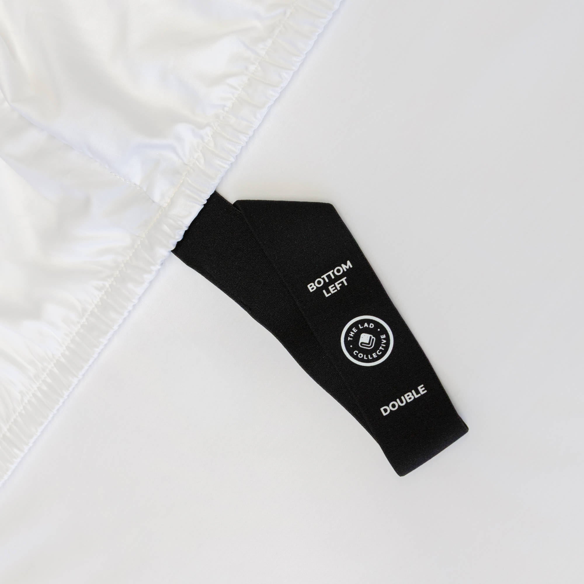 Close up of black corner strap in on white bedding