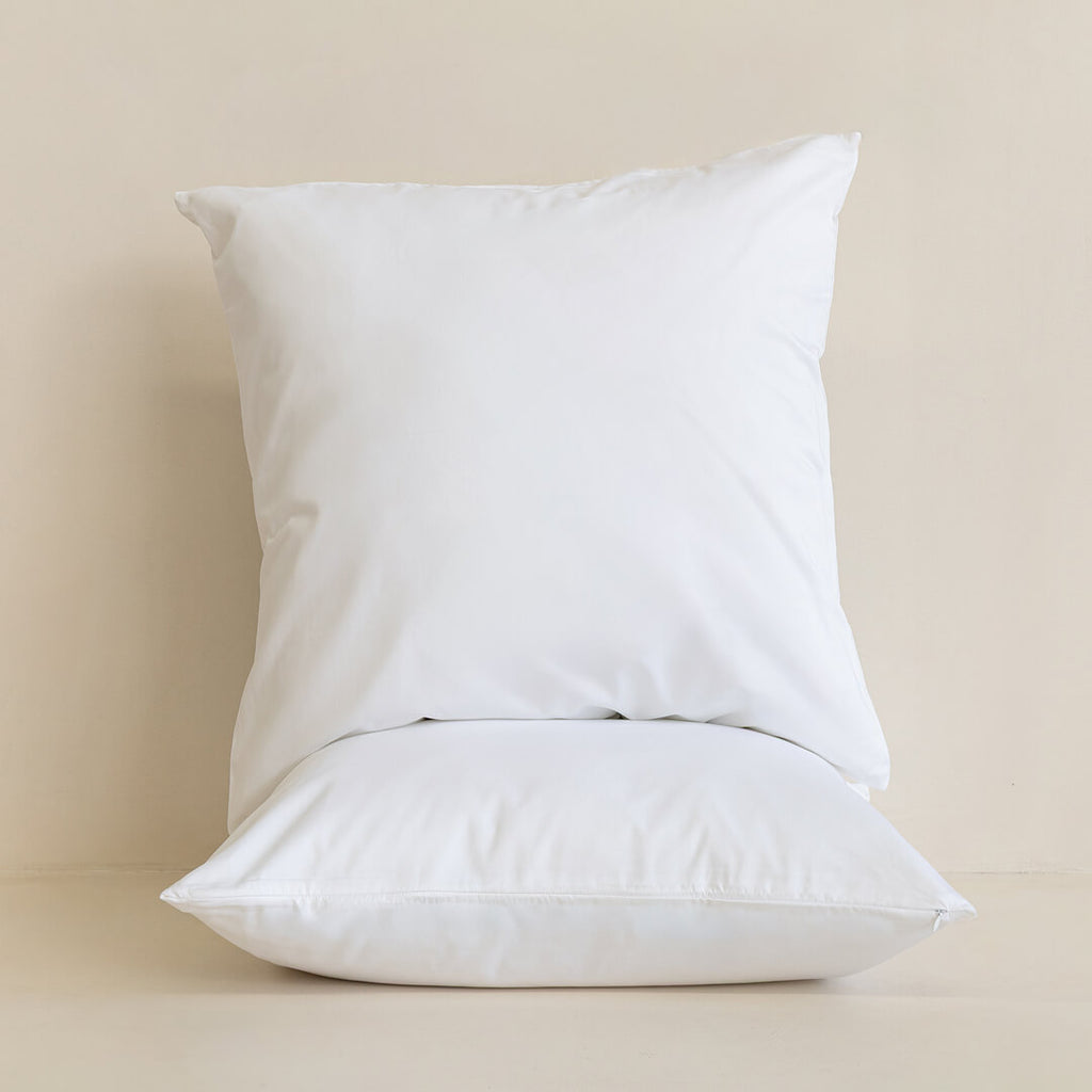 Two white pillows on a beige background