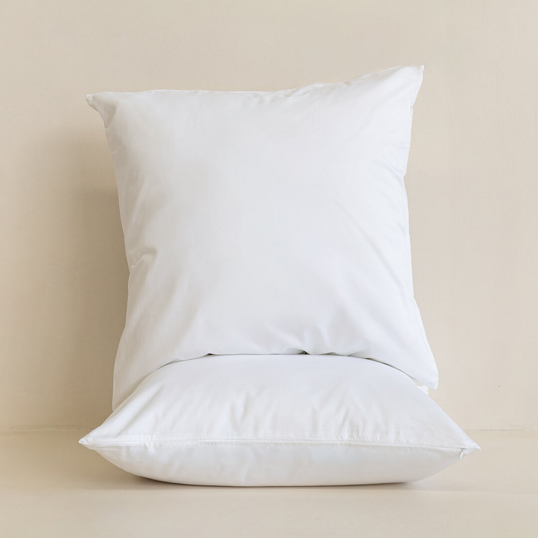 Two white pillows on a beige background