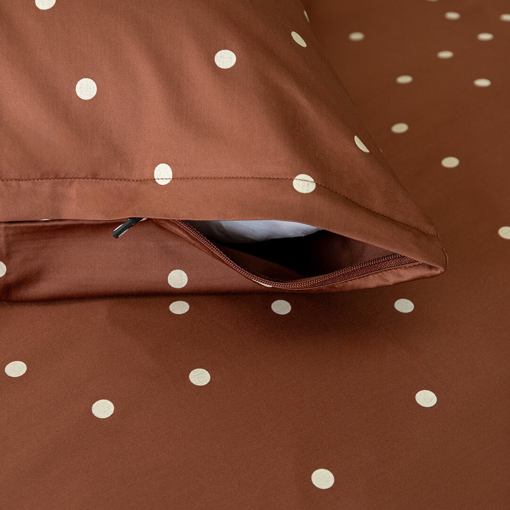 Brown fabric with white polka dots, folded over itself.