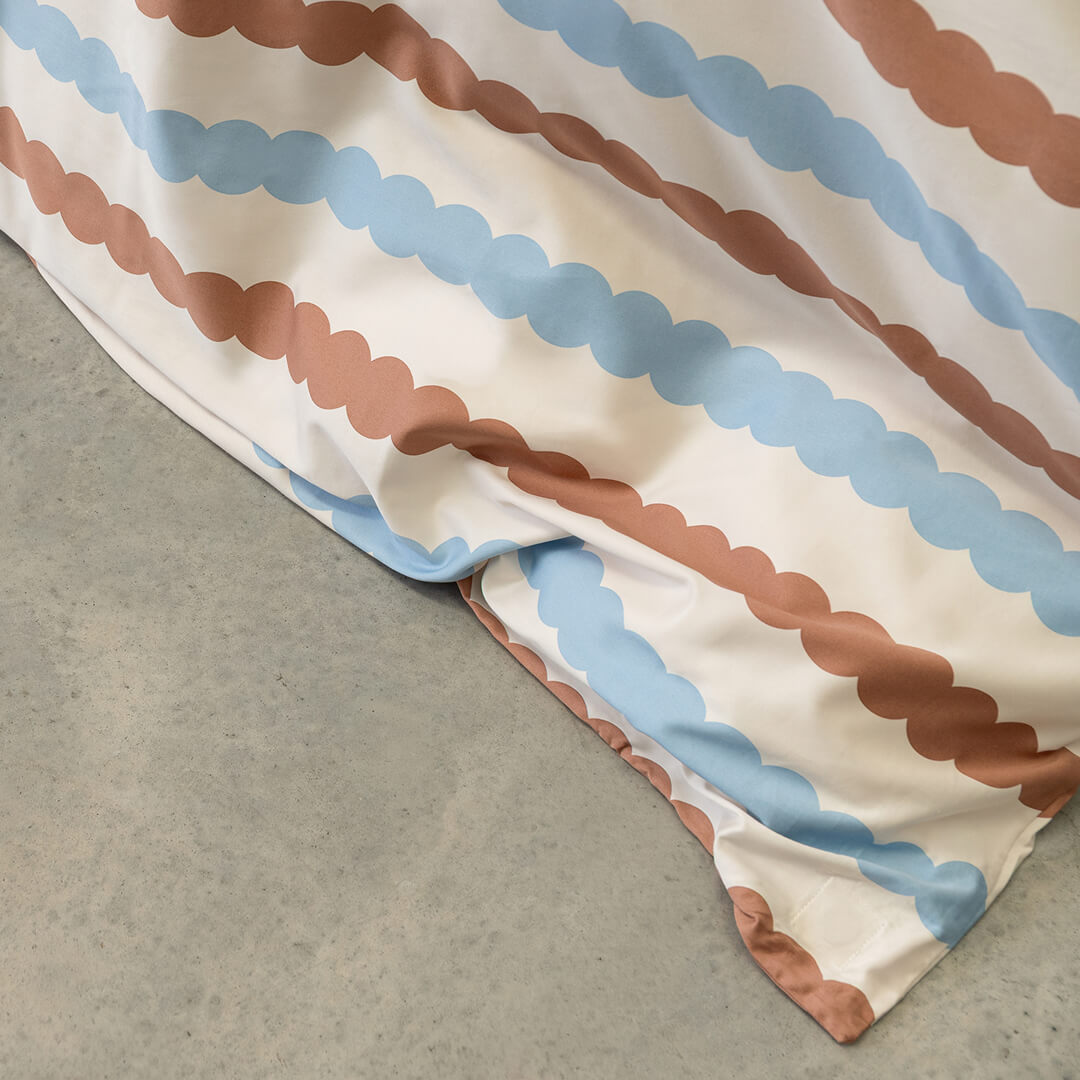 Close-up of a fabric with brown and blue striped pattern on a gray surface.