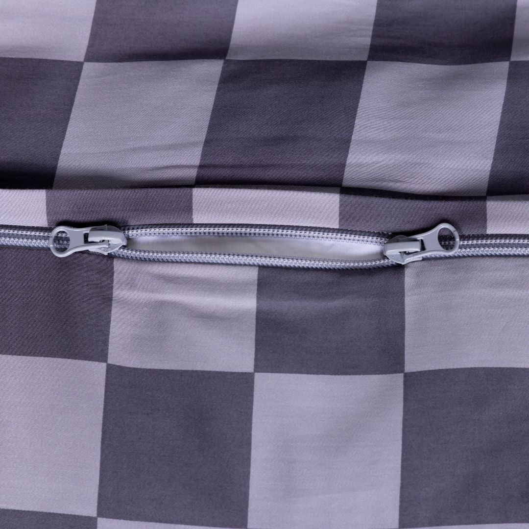 Close-up of grey checkered fabric with a zipper on quilt cover.
