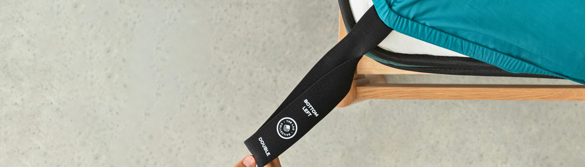 Close-up of a black strap with a brand logo on a teal chair.